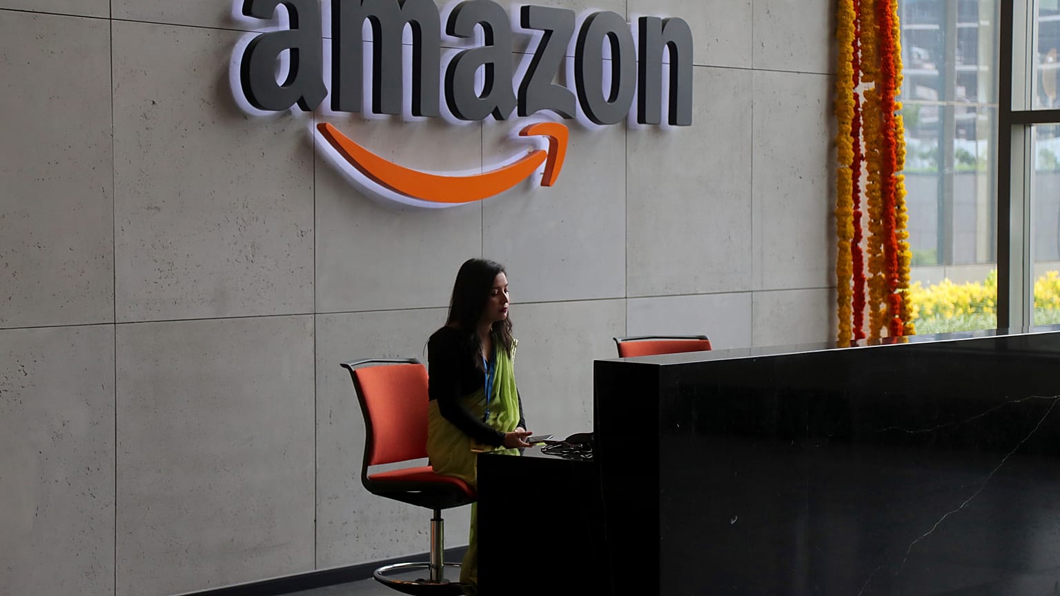 An Indian employee works at the reception desk of Amazon's newly inaugurated campus building in Hyderabad, India, Wednesday, Aug. 21, 2019.