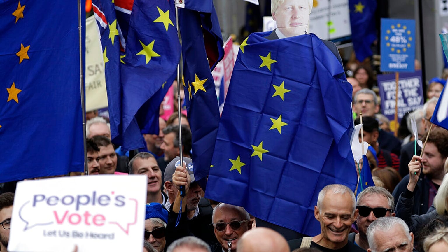 FILE - Anti-Brexit remain in the European Union supporters hold with former Prime Minister Boris Johnson draped in an EU flag as they demand another Brexit vote. 2019 