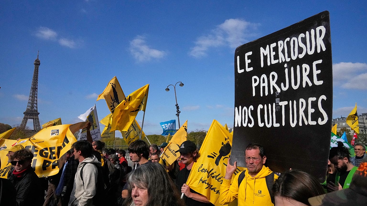 French farmers protest with a poster reading "Mercosur betrays our cultures" against the Mercosur trade deal Tuesday, Oct. 14, 2025, in Paris.