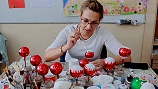Rossitsa Todorova, a Christmas bauble painter, decorates a glass ornament.