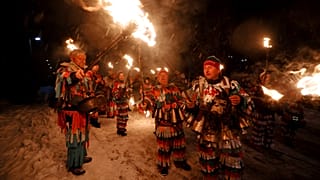 Bulgarian kukeri dancers light their torches as they perform Surva ritual celebrating the New Year.