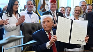 File - President Donald Trump displays an executive order reclassifying marijuana as a less dangerous drug in the Oval Office of the White House, Thursday, Dec. 18, 2025. 